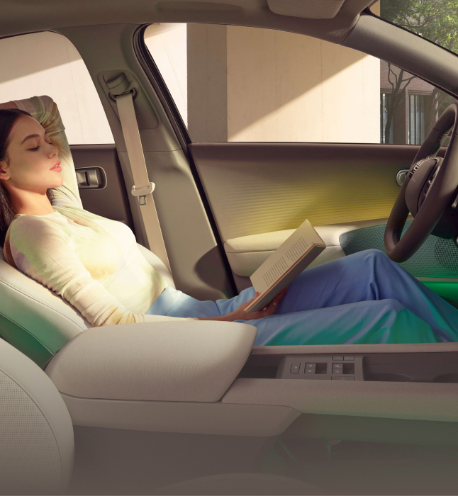 Woman reading a book while sitting in the driver's side seat in a park vehicle