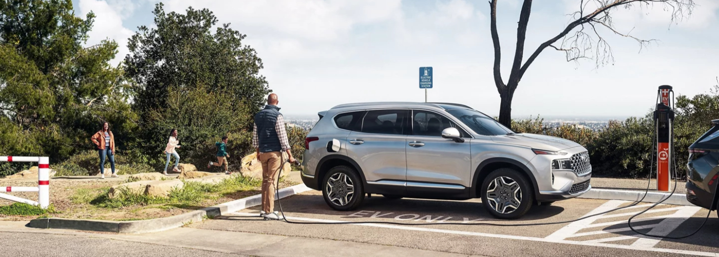 2023 Hyundai Santa Fe Plug-In Hybrid at Charging Station with Family