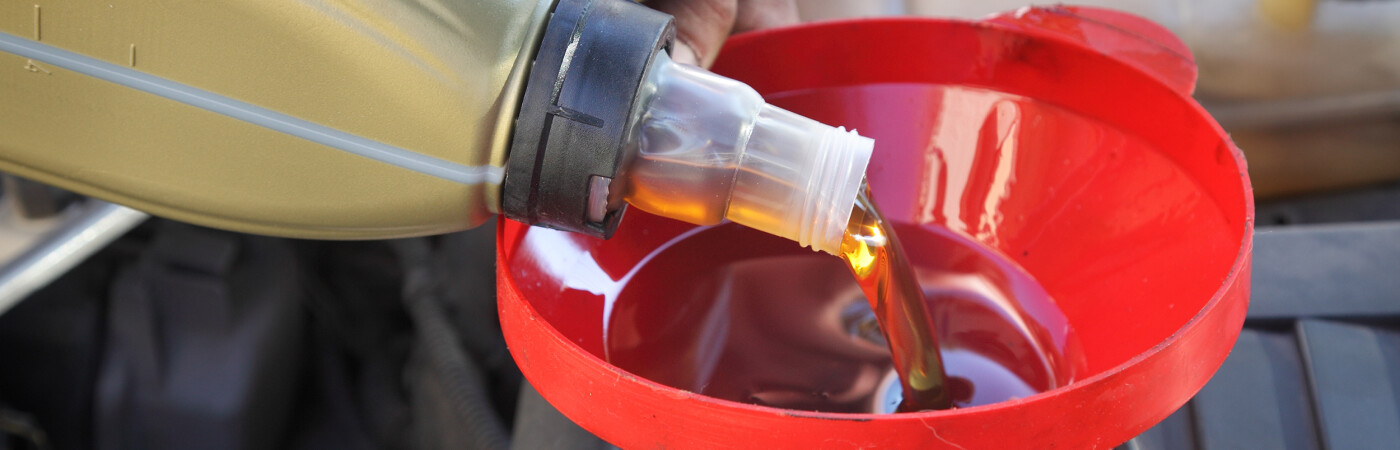 Pouring Oil into Funnel into Engine